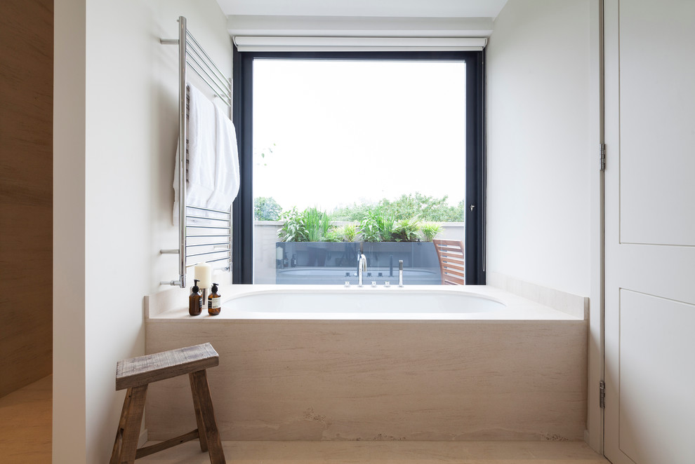 Inspiration for a scandinavian master bathroom remodel in London with an undermount tub and white walls