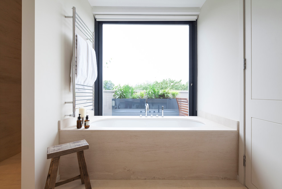Skandinavisk inredning av ett en-suite badrum, med ett undermonterat badkar och vita väggar