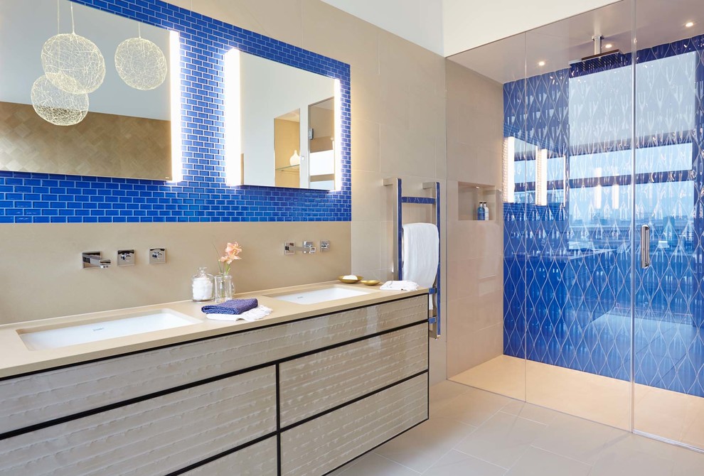 Inspiration för ett stort funkis en-suite badrum, med ett undermonterad handfat, släta luckor, bänkskiva i akrylsten, ett fristående badkar, en dubbeldusch, porslinskakel, vita väggar, klinkergolv i porslin, beige skåp och blå kakel