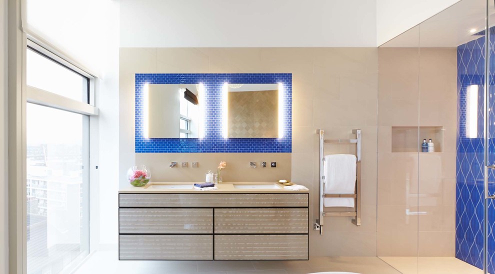 Идея дизайна: большая главная ванная комната в современном стиле с врезной раковиной, плоскими фасадами, бежевыми фасадами, столешницей из искусственного камня, отдельно стоящей ванной, двойным душем, синей плиткой, керамогранитной плиткой, белыми стенами и полом из керамогранита