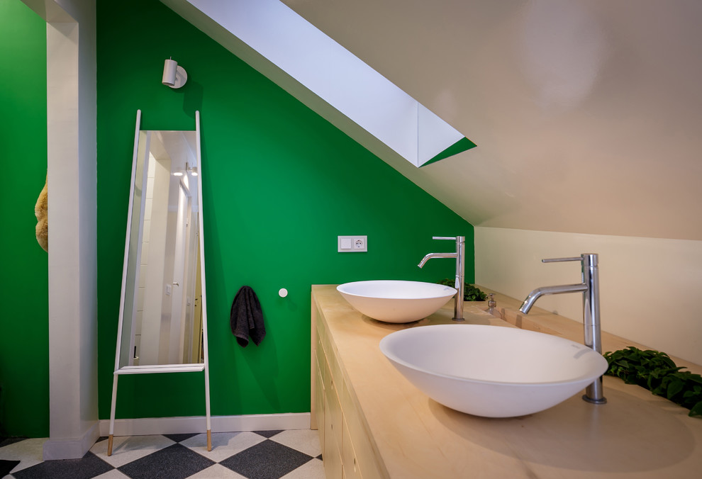 Inspiration pour une salle de bain principale nordique en bois clair de taille moyenne avec un placard en trompe-l'oeil, une baignoire sur pieds, une douche ouverte, WC à poser, un carrelage noir et blanc, des carreaux de céramique, un mur vert, un sol en carrelage de céramique, un lavabo de ferme et un plan de toilette en bois.