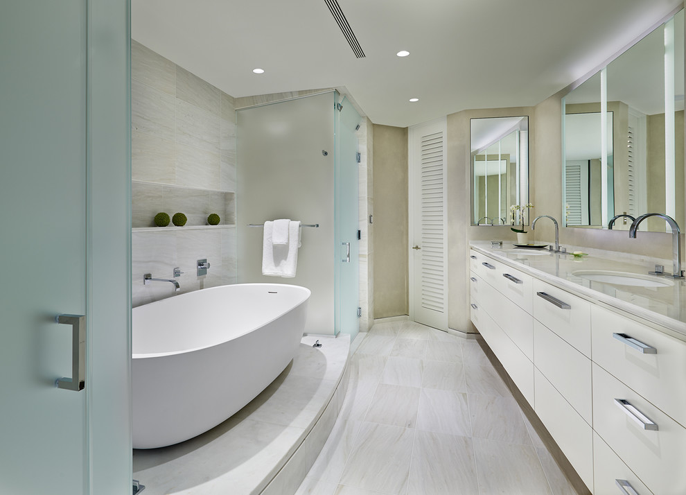 Modern inredning av ett mellanstort en-suite badrum, med släta luckor, vita skåp, ett fristående badkar, en dusch i en alkov, beige kakel, beige väggar, marmorgolv, ett undermonterad handfat, marmorbänkskiva, porslinskakel, beiget golv och dusch med gångjärnsdörr