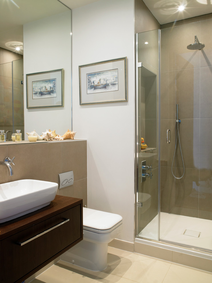 Immagine di una stanza da bagno chic con lavabo da incasso, ante lisce, ante grigie, top in pietra calcarea, vasca freestanding e pavimento in travertino