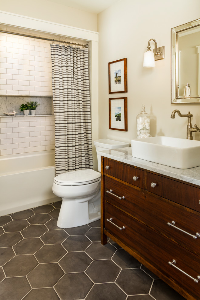 Diseño de cuarto de baño principal de estilo de casa de campo con puertas de armario de madera en tonos medios, bañera empotrada, sanitario de dos piezas, baldosas y/o azulejos blancos, baldosas y/o azulejos de cemento, paredes beige, lavabo sobreencimera, suelo gris, ducha con cortina, encimeras blancas y armarios con paneles lisos