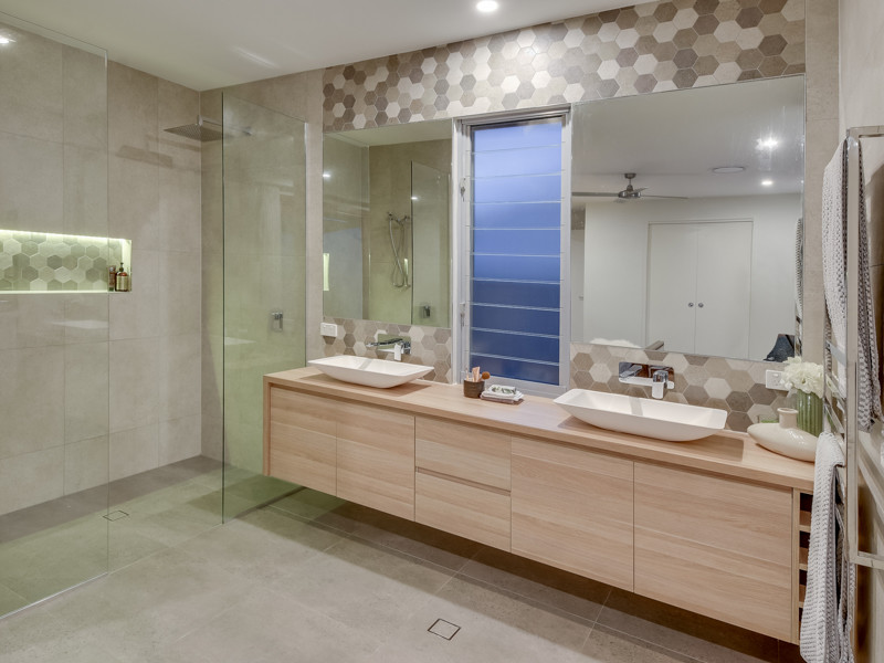 Свежая идея для дизайна: главная ванная комната среднего размера в современном стиле с фасадами островного типа, светлыми деревянными фасадами, отдельно стоящей ванной, открытым душем, инсталляцией, серой плиткой, керамогранитной плиткой, серыми стенами, полом из керамогранита, настольной раковиной, столешницей из ламината, серым полом и открытым душем - отличное фото интерьера