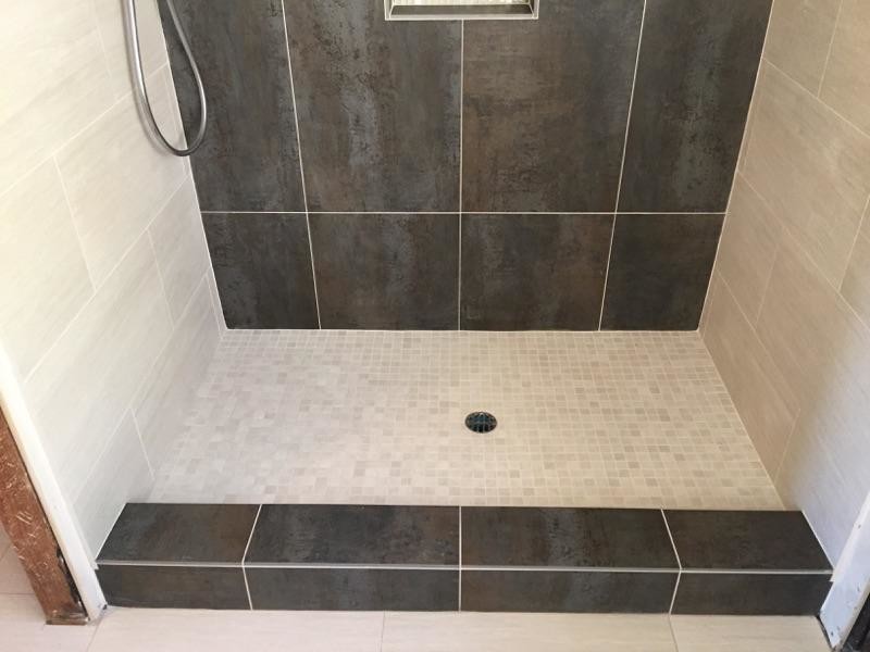 Photo of a medium sized contemporary ensuite bathroom in Orange County with a built-in sink, recessed-panel cabinets, brown cabinets, tiled worktops, a walk-in shower, a one-piece toilet, multi-coloured tiles, porcelain tiles, multi-coloured walls and porcelain flooring.