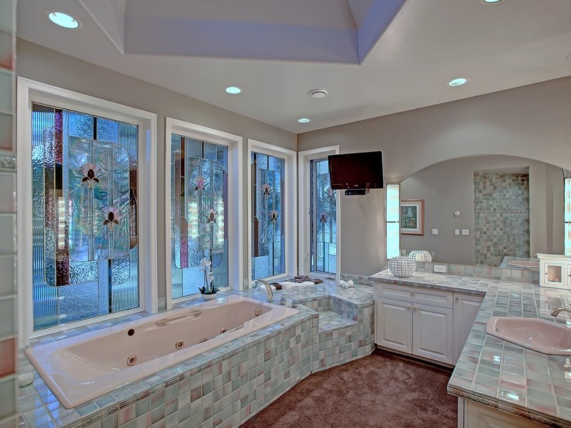 Idee per una stanza da bagno padronale stile americano con lavabo da incasso, ante con bugna sagomata, ante bianche, top piastrellato, vasca da incasso, piastrelle multicolore, piastrelle in ceramica e pareti grigie