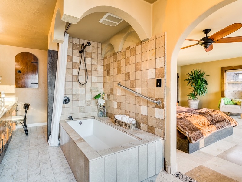 Inspiration for a mediterranean ensuite bathroom in Seattle with freestanding cabinets, light wood cabinets, marble worktops, a submerged bath, a shower/bath combination, multi-coloured tiles, stone tiles, yellow walls and ceramic flooring.