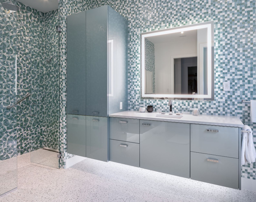 Свежая идея для дизайна: большая главная ванная комната в современном стиле с плоскими фасадами, синими фасадами, душем без бортиков, инсталляцией, разноцветной плиткой, полом из терраццо, столешницей из искусственного кварца, разноцветным полом, душем с распашными дверями, белой столешницей, врезной раковиной и зеркалом с подсветкой - отличное фото интерьера