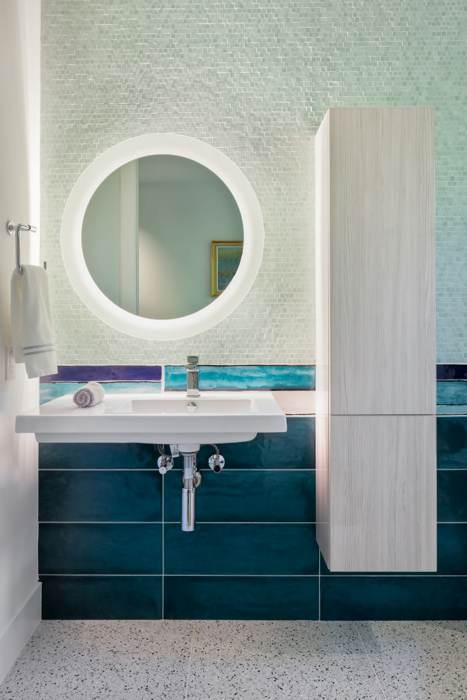 Modelo de cuarto de baño contemporáneo pequeño con armarios con paneles lisos, baldosas y/o azulejos azules, suelo de terrazo, aseo y ducha, lavabo suspendido, paredes blancas y suelo gris