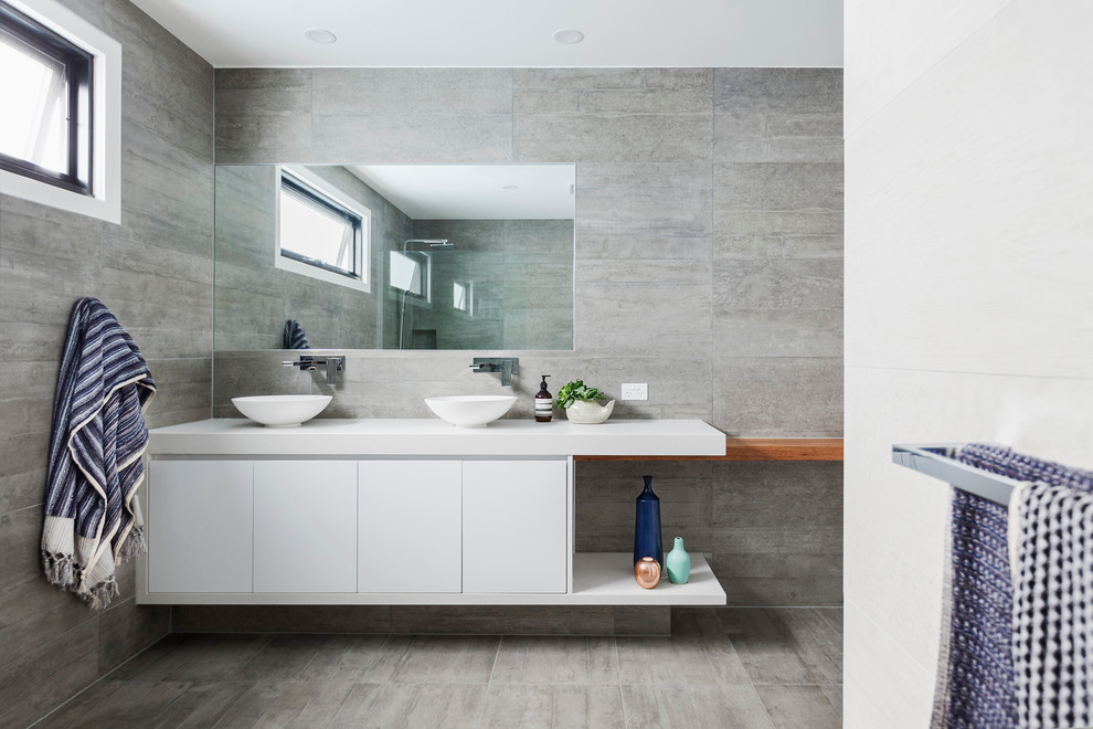 Diseño de cuarto de baño principal contemporáneo de tamaño medio con armarios con paneles lisos, puertas de armario blancas, paredes grises, suelo de cemento, lavabo sobreencimera y encimera de cuarzo compacto