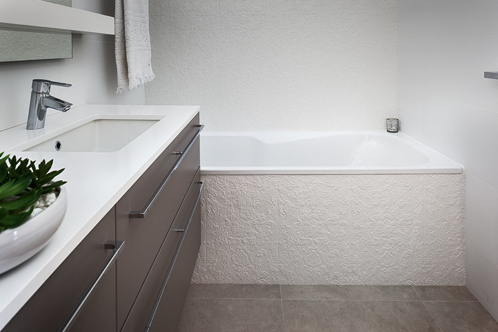 Imagen de cuarto de baño actual, grande, con lavabo bajoencimera, puertas de armario de madera oscura, encimera de cuarzo compacto, suelo de baldosas de cerámica y baldosas y/o azulejos beige