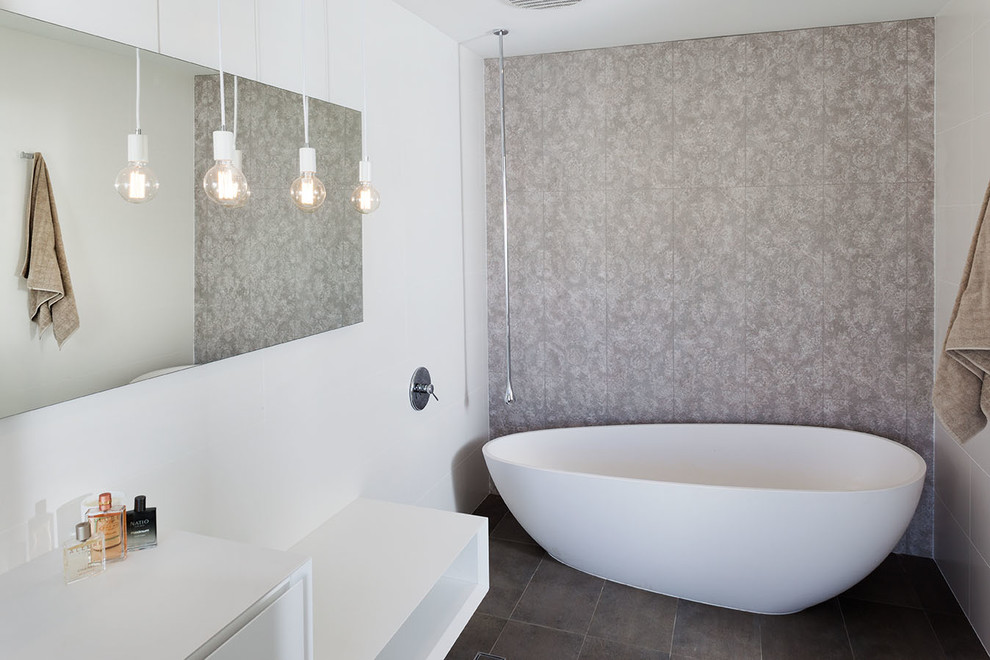 Bild på ett stort funkis en-suite badrum, med ett integrerad handfat, ett fristående badkar, vita väggar och klinkergolv i keramik