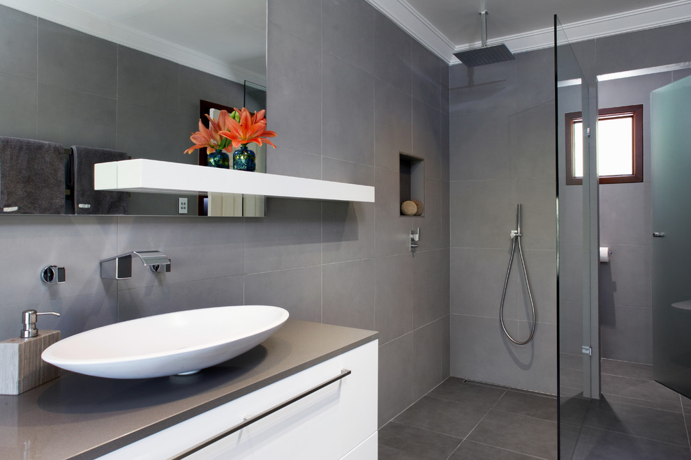 Idéer för ett stort modernt en-suite badrum, med vita skåp, bänkskiva i kvarts, ett fristående badkar, en öppen dusch, grå kakel, keramikplattor, grå väggar och klinkergolv i keramik