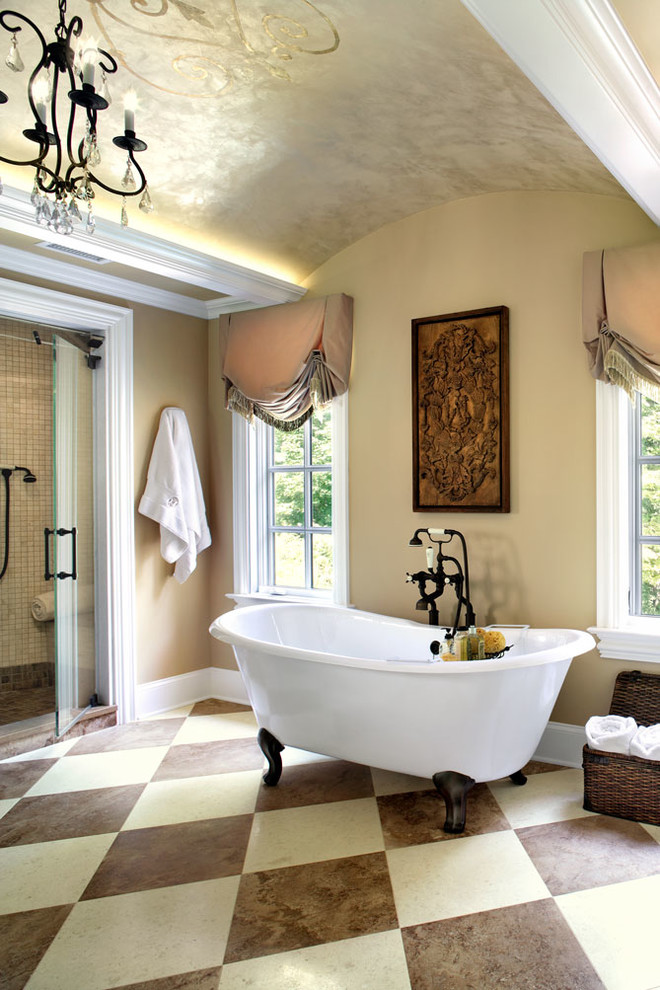 Bild på ett medelhavsstil badrum, med ett badkar med tassar, en dusch i en alkov och beige väggar