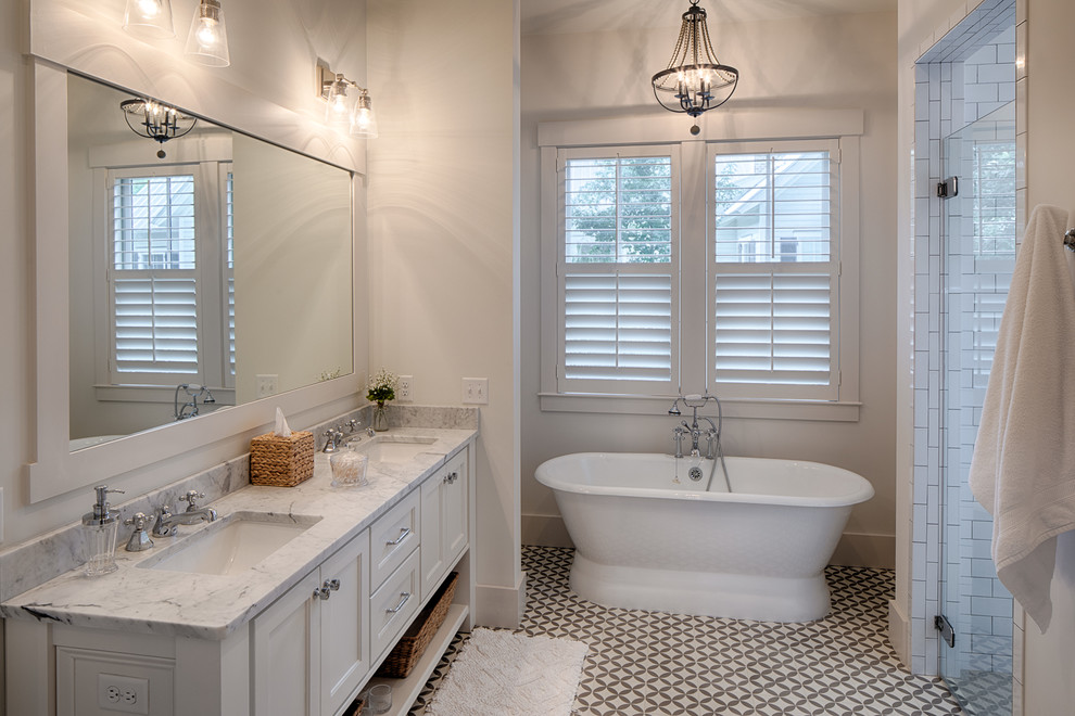 Exempel på ett lantligt beige beige badrum, med luckor med infälld panel, vita skåp, ett fristående badkar, en dusch i en alkov, vit kakel, tunnelbanekakel, beige väggar, ett undermonterad handfat, flerfärgat golv och dusch med gångjärnsdörr