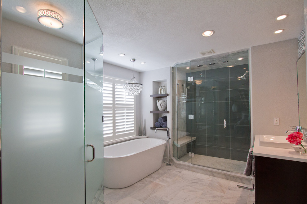 Example of a large minimalist master gray tile and glass tile marble floor and white floor bathroom design in Denver with a two-piece toilet, gray walls, a vessel sink, quartz countertops, a hinged shower door, recessed-panel cabinets and dark wood cabinets