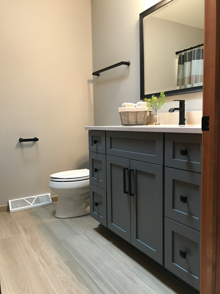 Design ideas for a medium sized traditional family bathroom in Milwaukee with shaker cabinets, grey cabinets, an alcove bath, an alcove shower, a two-piece toilet, blue walls, porcelain flooring, a submerged sink, engineered stone worktops, beige floors, a shower curtain, beige worktops, a single sink, a built in vanity unit and a vaulted ceiling.