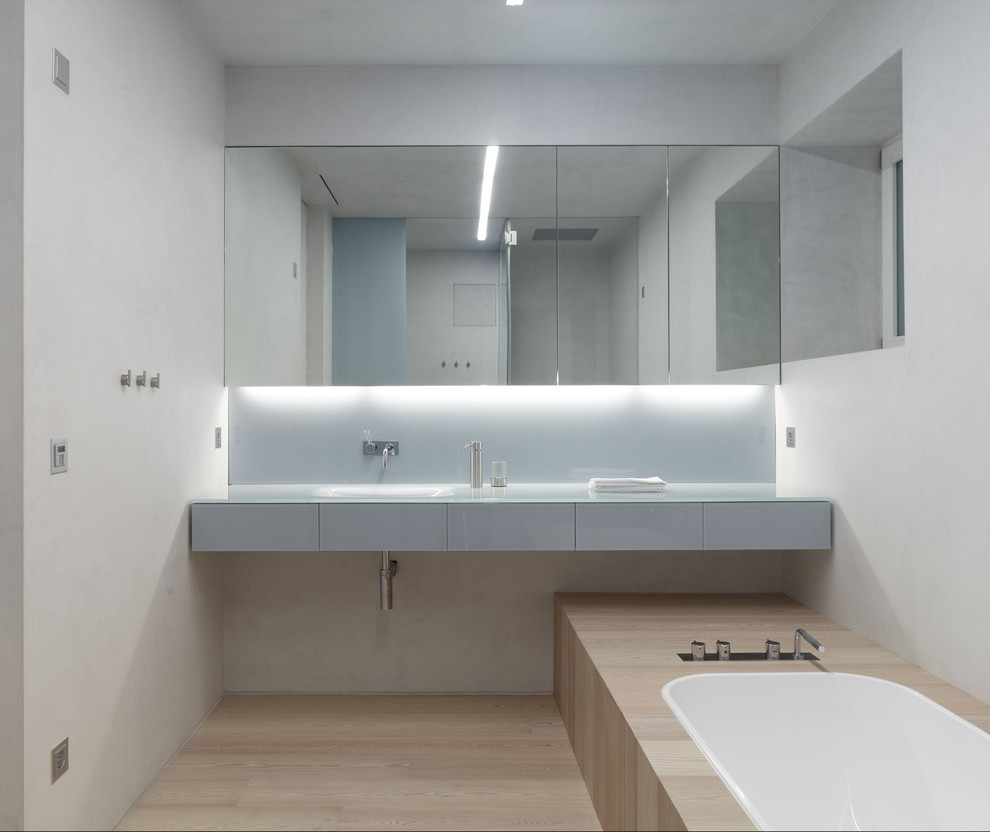 Bathroom - contemporary light wood floor bathroom idea in Other with white walls and glass-front cabinets