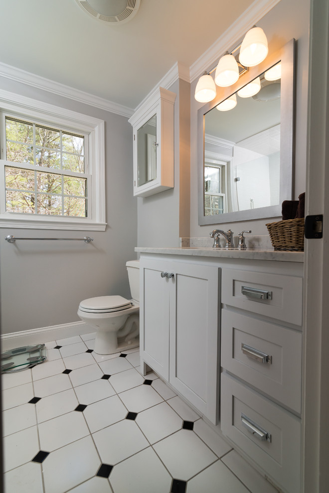 Esempio di una stanza da bagno moderna di medie dimensioni con ante in stile shaker, ante bianche, doccia ad angolo, pareti grigie, pavimento in vinile, lavabo sospeso e top in marmo