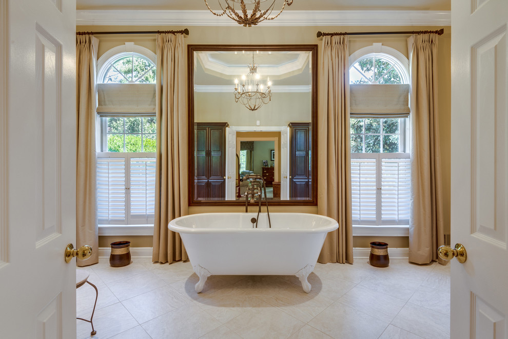 Claw-foot bathtub - traditional beige floor claw-foot bathtub idea in DC Metro with brown walls