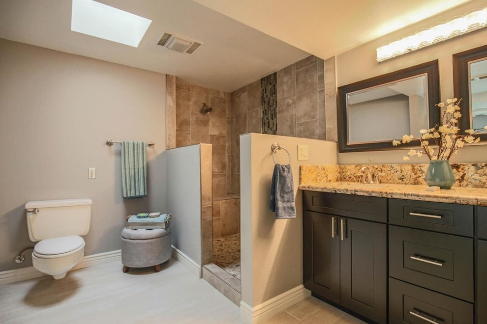 Photo of a large contemporary ensuite bathroom in Phoenix with shaker cabinets, dark wood cabinets, a corner shower, a wall mounted toilet, beige tiles, stone slabs, beige walls, ceramic flooring, a submerged sink, granite worktops, beige floors and an open shower.