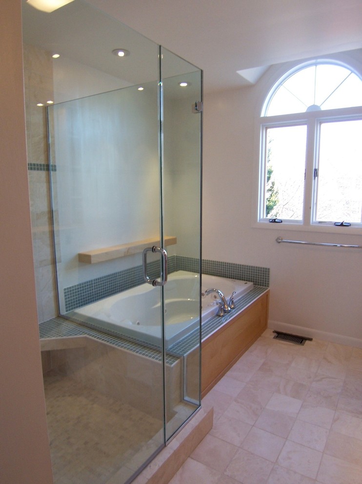 Inspiration för mellanstora moderna en-suite badrum, med ett nedsänkt handfat, släta luckor, skåp i ljust trä, bänkskiva i glas, ett platsbyggt badkar, en dubbeldusch, blå kakel, glaskakel, bruna väggar och travertin golv