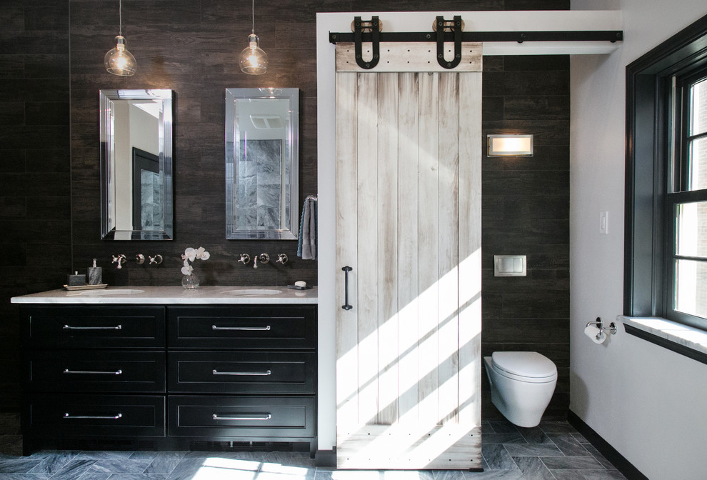 Eklektisk inredning av ett stort en-suite badrum, med ett undermonterad handfat, luckor med infälld panel, svarta skåp, marmorbänkskiva, ett fristående badkar, en kantlös dusch, en vägghängd toalettstol, grå kakel, stenkakel, vita väggar och marmorgolv