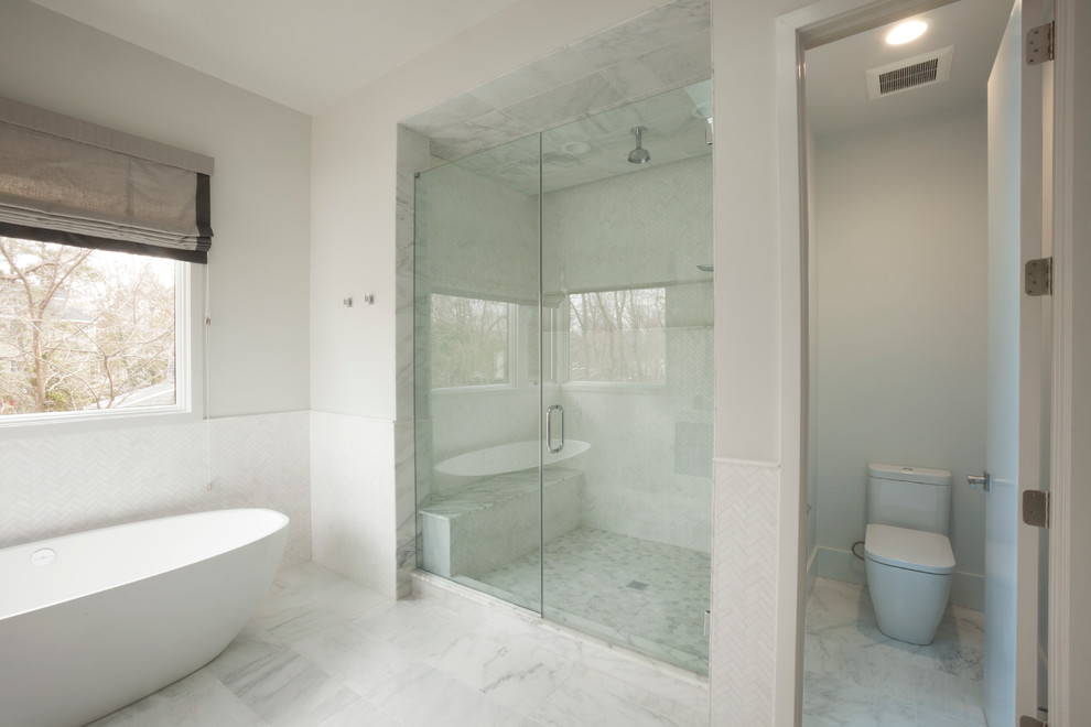 Idéer för att renovera ett mellanstort funkis en-suite badrum, med blå skåp, ett fristående badkar, en dusch i en alkov, en toalettstol med hel cisternkåpa, vit kakel, porslinskakel, vita väggar, klinkergolv i porslin, ett integrerad handfat, bänkskiva i akrylsten, vitt golv och dusch med gångjärnsdörr