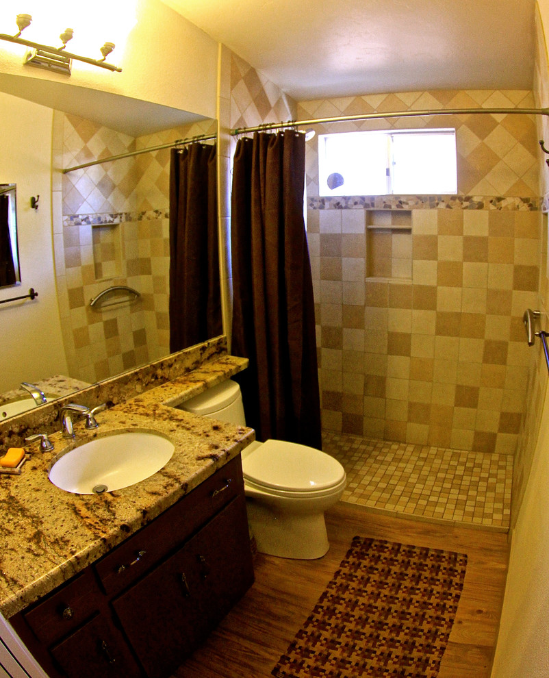 Bild på ett mellanstort rustikt en-suite badrum, med släta luckor, skåp i mellenmörkt trä, ljust trägolv, en hörndusch, en toalettstol med separat cisternkåpa, beige kakel, keramikplattor, beige väggar, granitbänkskiva och ett integrerad handfat