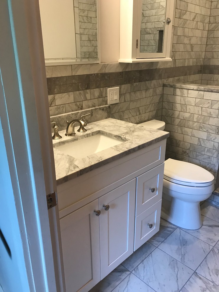 Cette photo montre une petite salle de bain moderne avec un placard à porte shaker, des portes de placard blanches, WC à poser, un carrelage gris, du carrelage en marbre, un mur blanc, un sol en marbre, un lavabo encastré, un plan de toilette en marbre, un sol gris, aucune cabine et un plan de toilette gris.