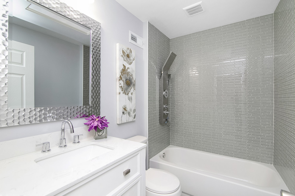 Foto på ett litet funkis vit badrum med dusch, med skåp i shakerstil, vita skåp, ett badkar i en alkov, en dusch/badkar-kombination, en toalettstol med separat cisternkåpa, grå kakel, stickkakel, lila väggar, ett undermonterad handfat, med dusch som är öppen och granitbänkskiva