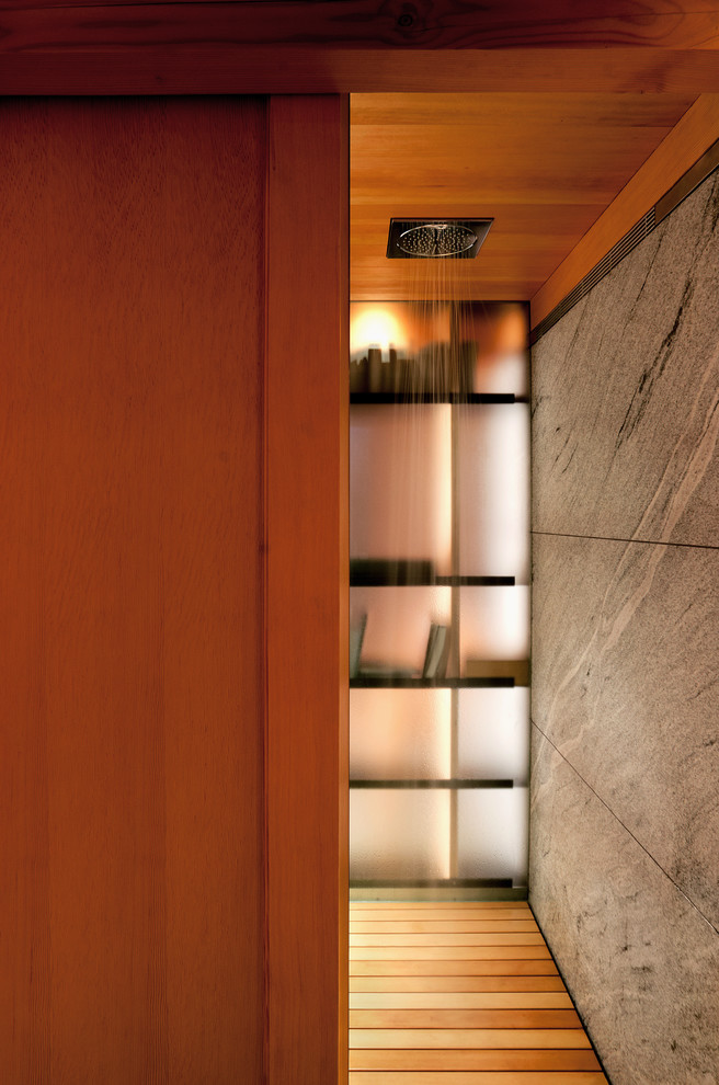 Immagine di una stanza da bagno di medie dimensioni con lavabo a bacinella, top in granito, doccia aperta, piastrelle grigie, piastrelle in pietra e pavimento in legno massello medio