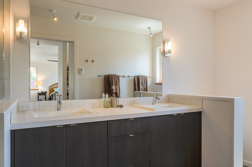 Medium sized modern ensuite bathroom in Seattle with a built-in sink, flat-panel cabinets, dark wood cabinets, engineered stone worktops, an alcove shower, a two-piece toilet, white tiles, glass sheet walls, white walls and porcelain flooring.