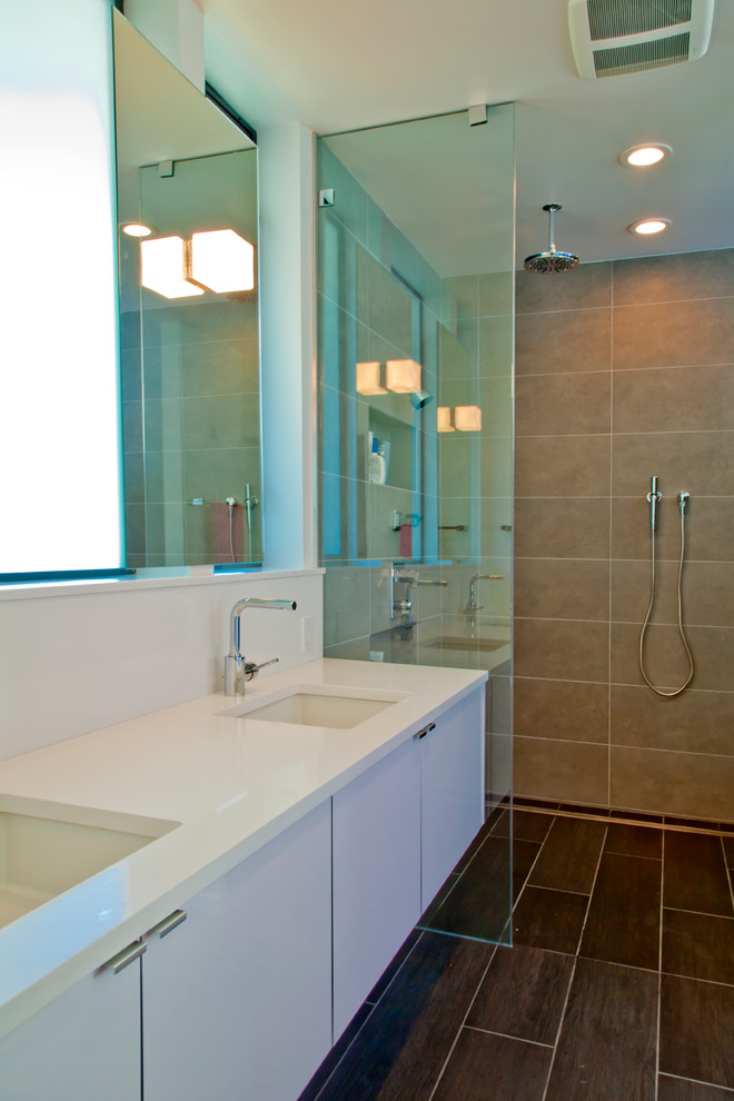 Esempio di una stanza da bagno contemporanea con lavabo sottopiano, ante lisce, ante bianche, doccia a filo pavimento, piastrelle beige e top bianco