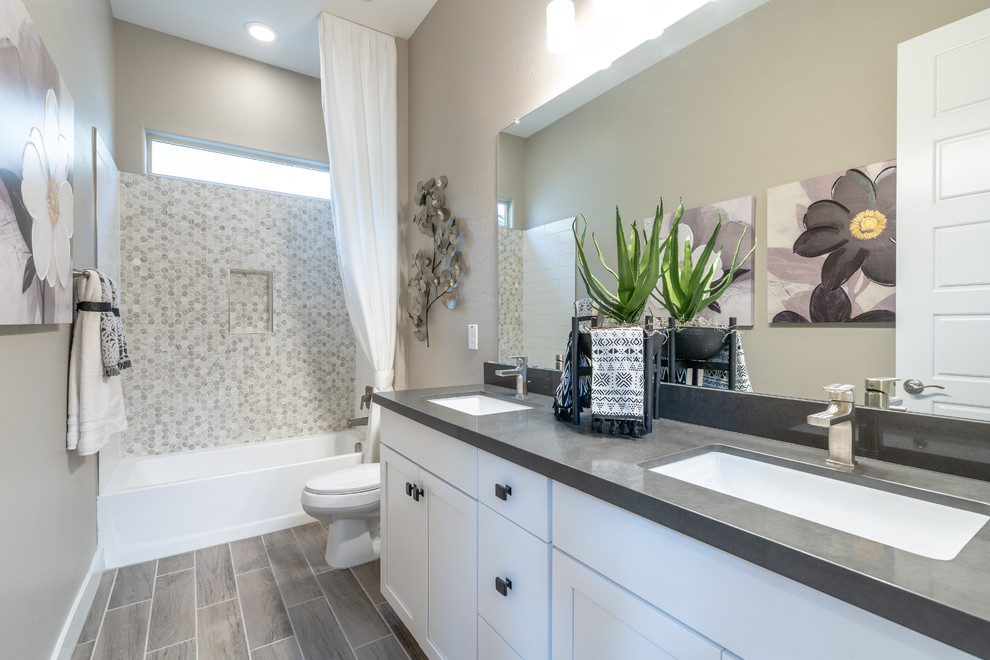 Example of a mid-sized trendy kids' beige tile and mosaic tile limestone floor and beige floor bathroom design in Phoenix with recessed-panel cabinets, white cabinets, beige walls, an undermount sink, solid surface countertops and gray countertops