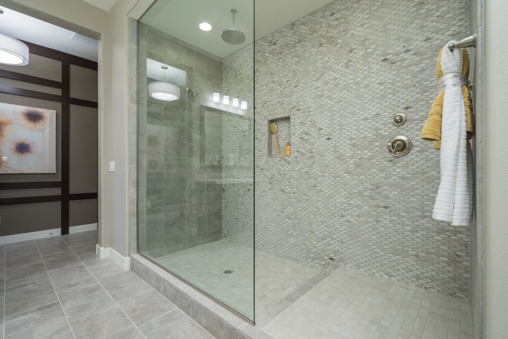Large trendy master gray tile and porcelain tile porcelain tile and gray floor bathroom photo in Phoenix with recessed-panel cabinets, dark wood cabinets, beige walls, an undermount sink, solid surface countertops and a hinged shower door