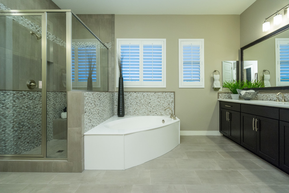 Exempel på ett stort modernt en-suite badrum, med luckor med infälld panel, svarta skåp, ett hörnbadkar, en hörndusch, grå kakel, glasskiva, beige väggar, klinkergolv i porslin, ett undermonterad handfat, bänkskiva i akrylsten, beiget golv och dusch med gångjärnsdörr