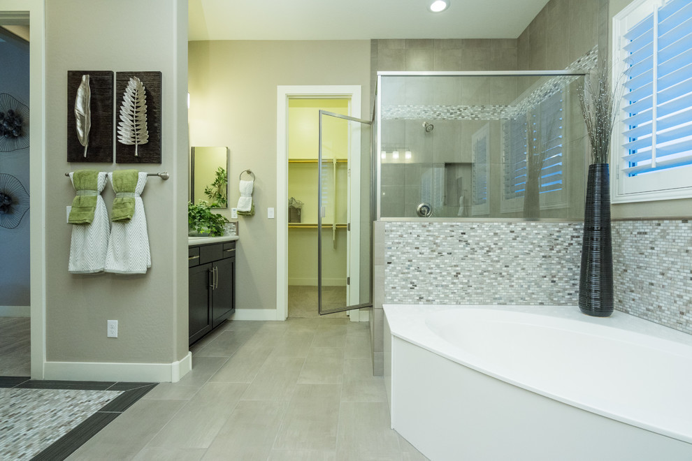 Inredning av ett modernt stort en-suite badrum, med luckor med infälld panel, svarta skåp, ett hörnbadkar, en hörndusch, grå kakel, glasskiva, beige väggar, klinkergolv i porslin, ett undermonterad handfat, bänkskiva i akrylsten, beiget golv och dusch med gångjärnsdörr