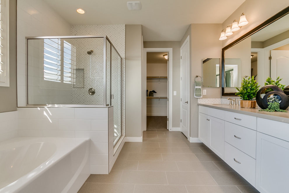 Large trendy master beige tile and glass sheet ceramic tile and beige floor bathroom photo in Phoenix with recessed-panel cabinets, white cabinets, beige walls, an undermount sink, solid surface countertops and a hinged shower door