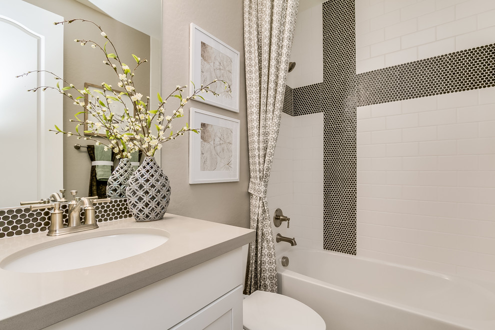 Inspiration for a large contemporary kids' white tile and ceramic tile ceramic tile and beige floor bathroom remodel in Phoenix with recessed-panel cabinets, white cabinets, beige walls, an undermount sink, solid surface countertops and a hinged shower door
