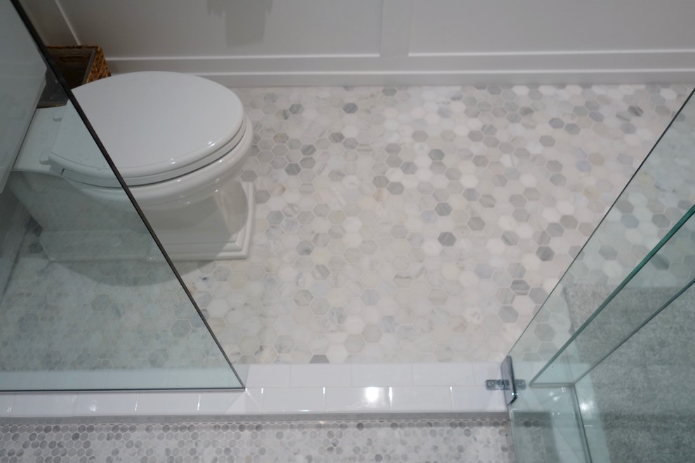 Aménagement d'une salle d'eau classique avec un placard en trompe-l'oeil, des portes de placard grises, une douche d'angle, WC à poser, un carrelage blanc, un carrelage de pierre, un mur gris, un sol en marbre, un lavabo encastré et un plan de toilette en marbre.