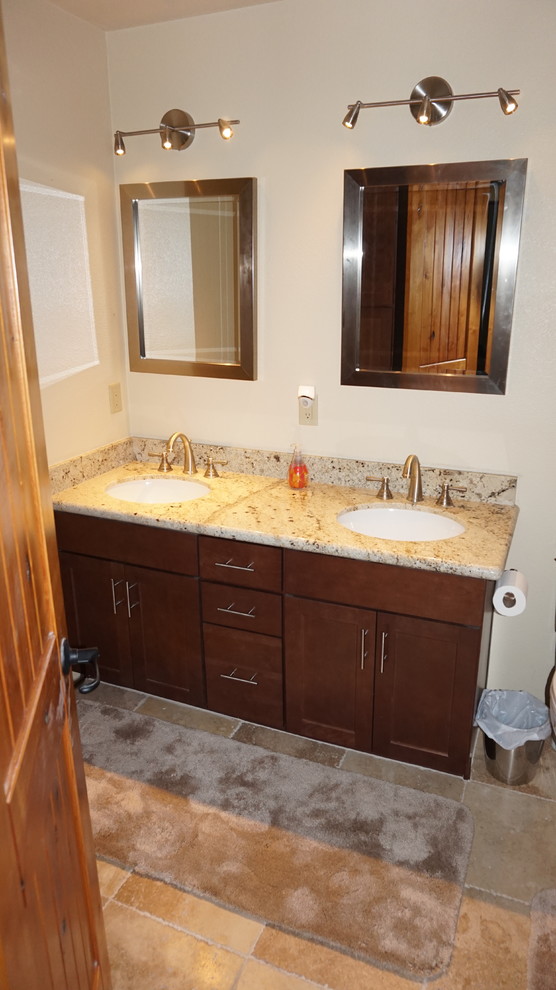 Exemple d'une salle d'eau chic en bois foncé avec un lavabo encastré, un placard à porte shaker, un plan de toilette en granite, une baignoire posée, un combiné douche/baignoire, WC séparés, un carrelage beige, des carreaux de béton et un mur beige.