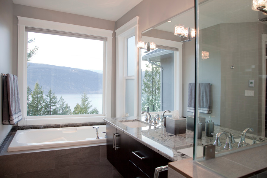 Design ideas for a traditional ensuite bathroom in Vancouver with a submerged sink, flat-panel cabinets, dark wood cabinets, granite worktops, an alcove bath, an alcove shower, a one-piece toilet, grey tiles, mosaic tiles, grey walls and ceramic flooring.