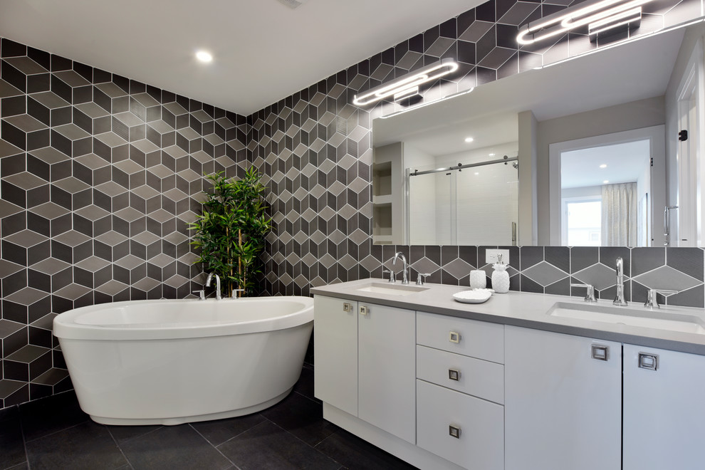 Esempio di una stanza da bagno padronale minimal con ante lisce, ante bianche, vasca freestanding, lavabo sottopiano, pareti nere e pavimento nero