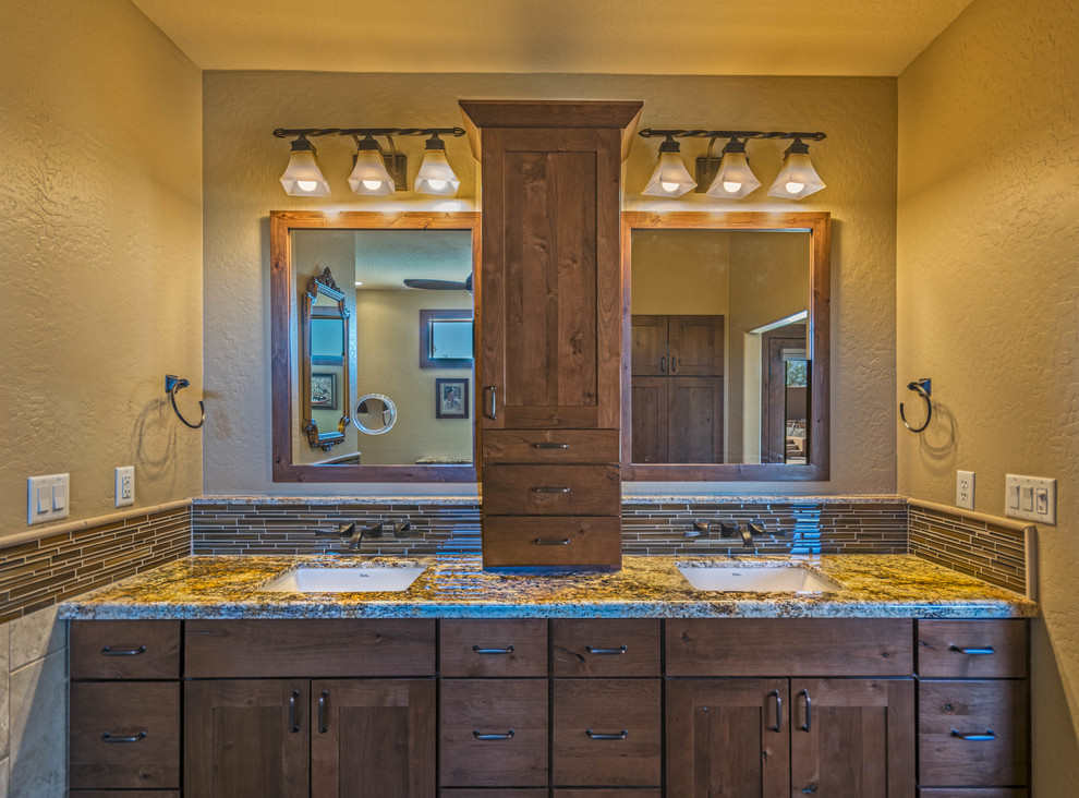 Immagine di una stanza da bagno padronale tradizionale di medie dimensioni con ante in legno bruno, piastrelle marroni, piastrelle di vetro, pareti beige, lavabo sottopiano, top in granito e ante in stile shaker