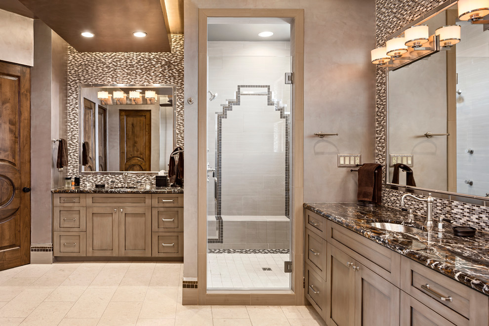Photo of a classic bathroom in Phoenix with shaker cabinets, brown cabinets, a corner shower, grey tiles, brown walls, a submerged sink and a hinged door.