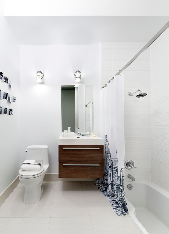 Industrial ensuite bathroom in Toronto with an integrated sink, freestanding cabinets, medium wood cabinets, engineered stone worktops, a one-piece toilet, white tiles, ceramic tiles, white walls, porcelain flooring and an alcove bath.