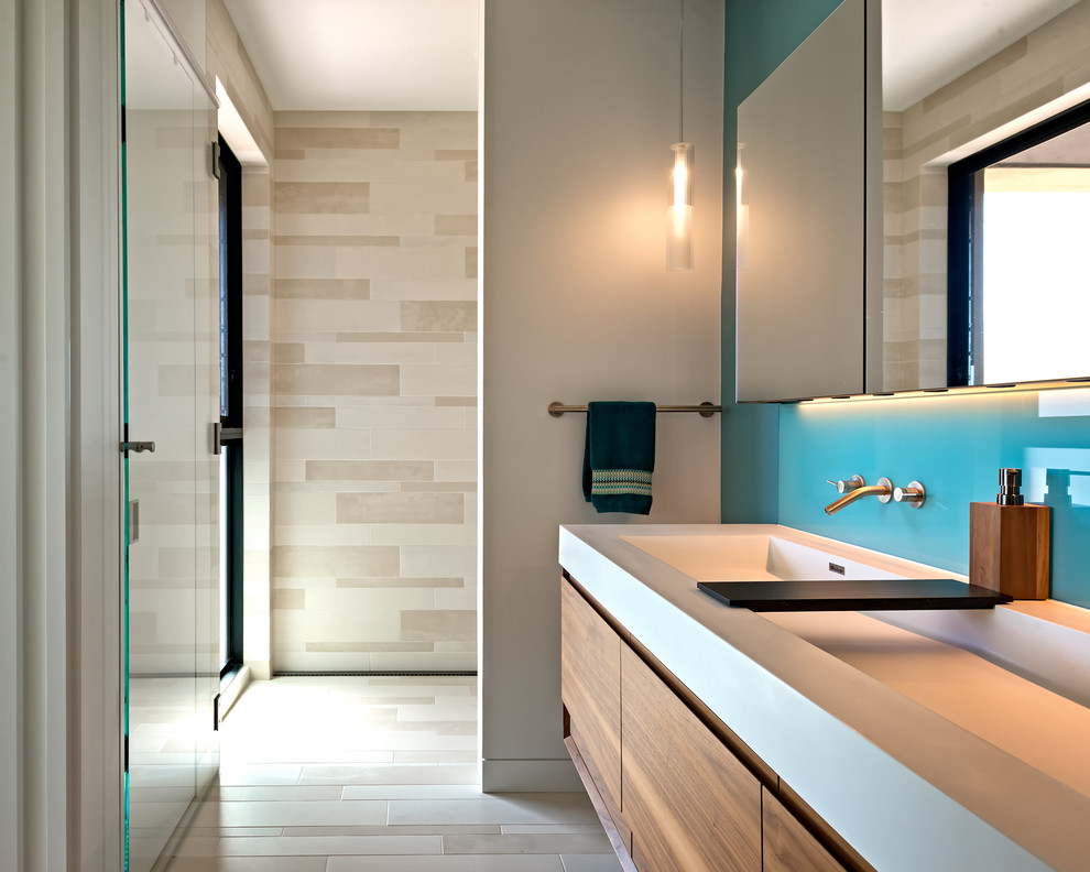 Inspiration for a contemporary bathroom in San Francisco with flat-panel cabinets, medium wood cabinets, beige walls, a trough sink and beige floors.