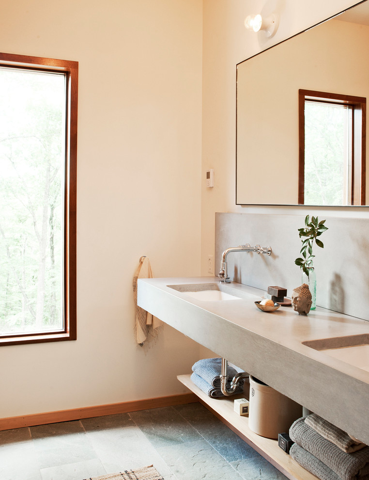 Immagine di una stanza da bagno padronale stile marinaro di medie dimensioni con nessun'anta, pavimento in ardesia, lavabo sottopiano e top in cemento